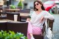 Young caucasian girl listening music in outdoor cafe Royalty Free Stock Photo