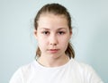 Young Caucasian girl with a neutral expression on her face. Portrait on grey background, emotions series Royalty Free Stock Photo