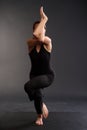 young caucasian girl in sportswear doing yoga or pilates exercise. Standing in Eagle Pose, Garudasana. Asana practice