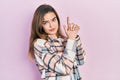Young caucasian girl wearing casual clothes holding symbolic gun with hand gesture, playing killing shooting weapons, angry face Royalty Free Stock Photo