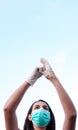 Young caucasian girl wearing a corona virus protection mask and putting on protective gloves