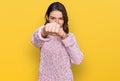 Young caucasian girl wearing wool winter sweater punching fist to fight, aggressive and angry attack, threat and violence Royalty Free Stock Photo