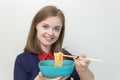 Young caucasian girl woman eating instant noodles ramen with chopsticks Royalty Free Stock Photo