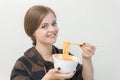 Young caucasian girl woman eating instant noodles ramen with chopsticks Royalty Free Stock Photo