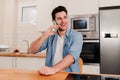 Young caucasian handsome guy having a friendly telephone call conversation sitting at home with positive expression. One Royalty Free Stock Photo