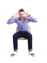 Young caucasian handsome man sitting on the chair isolated