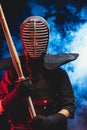 Young kendo fighter in armor practicing with bamboo sword