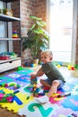 Young caucasian kid playing at kindergarten with toys. Preschooler boy happy at playroom Royalty Free Stock Photo