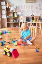 Young caucasian kid playing at kindergarten with toys. Preschooler boy happy at playroom Royalty Free Stock Photo