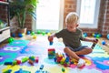 Young caucasian kid playing at kindergarten with toys. Preschooler boy happy at playroom Royalty Free Stock Photo