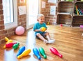 Young caucasian kid playing at kindergarten with toys. Preschooler boy happy at playroom Royalty Free Stock Photo