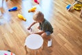 Young caucasian kid playing at kindergarten with toys. Preschooler boy happy at playroom Royalty Free Stock Photo