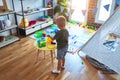 Young caucasian kid playing at kindergarten with toys. Preschooler boy happy at playroom Royalty Free Stock Photo