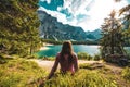 Young caucasian lady admiring the view of Baires Lake in the Dolomite mountains, South Tirol, Italy Royalty Free Stock Photo