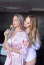 Young lesbian couple smelling tulip indoor