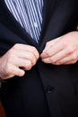 Young Caucasian male buttoning his suit jacket