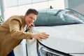 Young caucasian male dream about new car in dealership