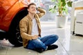 Young caucasian male dream about new car in dealership