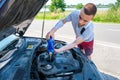 Man with an amputated arm pouring oil, adding engine oil in engine motor car Royalty Free Stock Photo