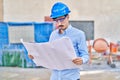 Young caucasian man architect looking house plans at street Royalty Free Stock Photo