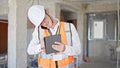 Young caucasian man architect talking on smartphone using touchpad at construction site Royalty Free Stock Photo