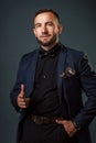 This is a young Caucasian man with a beard in a business suit and a black shirt. Studio portrait on a gray background Royalty Free Stock Photo