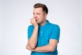 Young caucasian man in blue shirt biting nails being stressed or nervous. Royalty Free Stock Photo