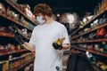 Young Caucasian man buyer wearing face protective mask during the shopping. Healthy lifestyle concept
