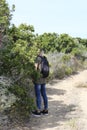 Young man peeing behind a tree