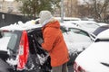 Young Caucasian man cleaning snow from car with brush. Transport, winter, people and vehicle concept. Royalty Free Stock Photo