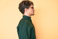 Young caucasian man with curly hair wearing casual clothes and glasses looking to side, relax profile pose with natural face with Royalty Free Stock Photo