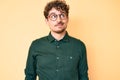 Young caucasian man with curly hair wearing casual clothes and glasses smiling looking to the side and staring away thinking Royalty Free Stock Photo