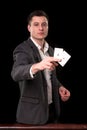 Young caucasian man wearing suit holding two aces in his hand on black background. Gambling concept. Casino Royalty Free Stock Photo