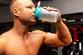 Young caucasian man drinking water after exercise.man in the gym drinking from the shaker