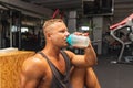 Young caucasian man drinking water after exercise.man in the gym drinking from the shaker