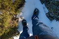 MAN`S LEG WEARING JEANS PANTS AND MOUNTAIN BOOTS FLOORING SNOW