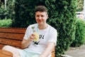 Young caucasian man with glass of lemonade in outdoor cafe, having brunch on sunny day. Portrait, cocktail Royalty Free Stock Photo