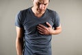 Young caucasian man grabs his hands for heart, heart attack. Heart problems concept. Medical and pharmaceutical concept Royalty Free Stock Photo