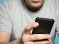 Young caucasian man in a gray t-shirt smartphone