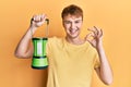 Young caucasian man holding big electric lantern doing ok sign with fingers, smiling friendly gesturing excellent symbol Royalty Free Stock Photo