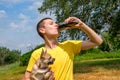 Young caucasian man holding Chihuahua dog and drinks cola outdoors Royalty Free Stock Photo