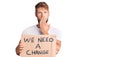 Young caucasian man holding we need a change banner covering mouth with hand, shocked and afraid for mistake