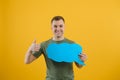 Young caucasian man isolated on yellow background holding a thinking speech bubble and doing OK sign