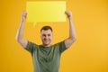 Young caucasian man isolated on yellow background holding a thinking speech bubble and doing OK sign