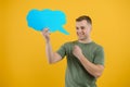 Young caucasian man isolated on yellow background holding a thinking speech bubble and doing OK sign