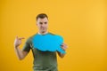 Young caucasian man isolated on yellow background holding a thinking speech bubble and doing OK sign