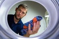 Young caucasian man loading washing machine. Man making houseworks Royalty Free Stock Photo