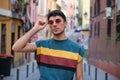 Young caucasian man with long false nails posing with his sunglasses at street.