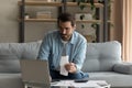 Young Caucasian man manage household finances using laptop