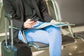 Young caucasian man with newspaper and cellphone at the airport while waiting for boarding. Casual young businessman Royalty Free Stock Photo